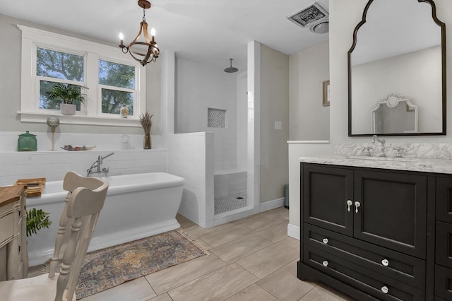5855 Gladys Ave, Beaumont, TX 77706 - full bathroom with vanity, a shower stall, a freestanding tub, a chandelier, and tile patterned floors
