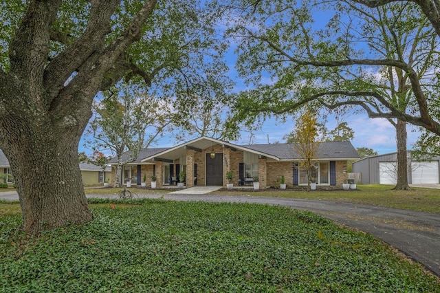 5855 Gladys Ave, Beaumont, TX 77706 - view of front of property with brick siding, a front lawn, driveway, and an outdoor structure