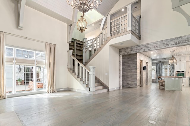 entryway with hardwood / wood-style flooring, a high ceiling, and an inviting chandelier