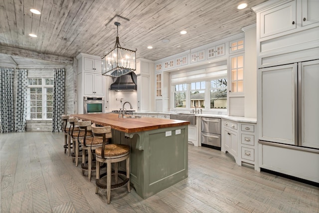 kitchen featuring a kitchen island, white cabinetry, butcher block counters, oven, and wood ceiling