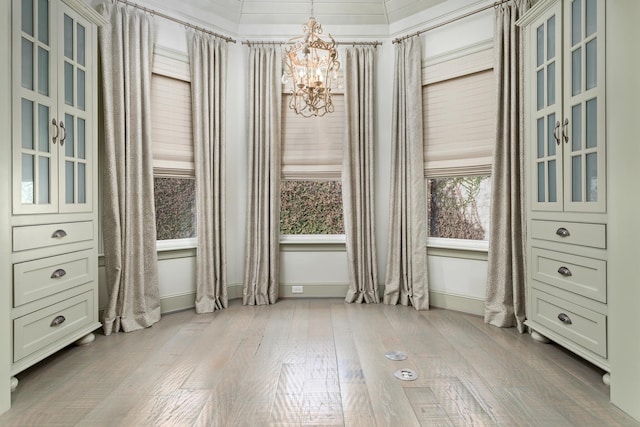 unfurnished dining area featuring a notable chandelier and light hardwood / wood-style floors