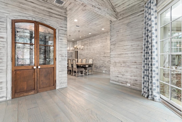 entryway with wooden walls, hardwood / wood-style floors, and a notable chandelier