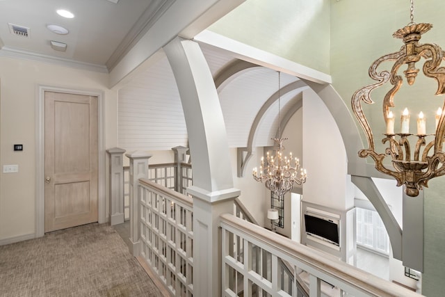 hallway featuring crown molding, carpet flooring, and a chandelier