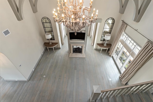 living room with hardwood / wood-style flooring and a towering ceiling