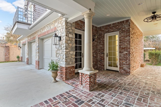 property entrance with ceiling fan, a garage, and a balcony