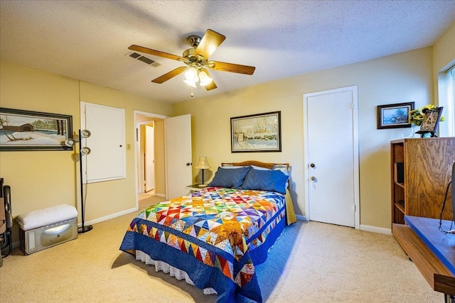 bedroom with light carpet, a textured ceiling, and ceiling fan