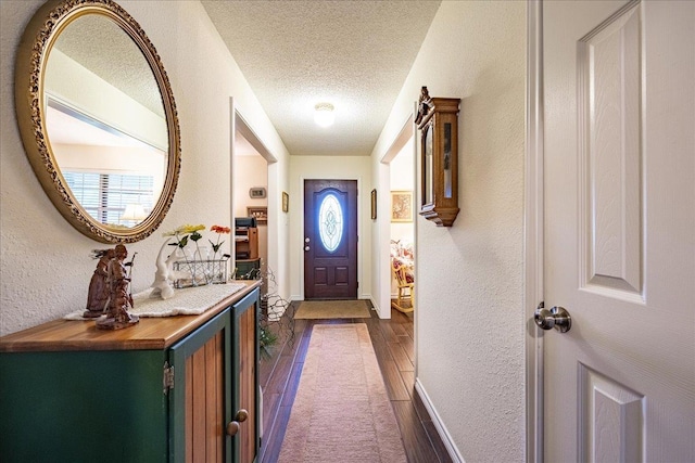 doorway featuring a textured ceiling and dark hardwood / wood-style floors