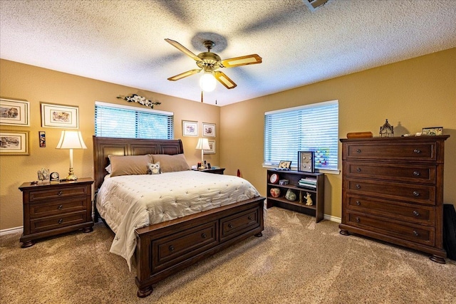 bedroom featuring a textured ceiling, light colored carpet, and ceiling fan