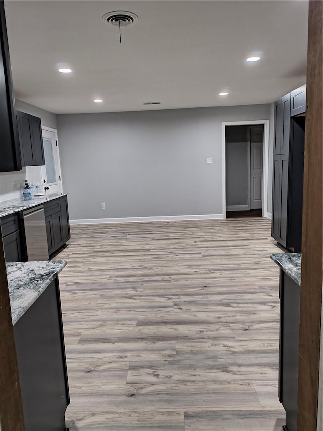 kitchen featuring light stone countertops, dishwasher, and light hardwood / wood-style floors