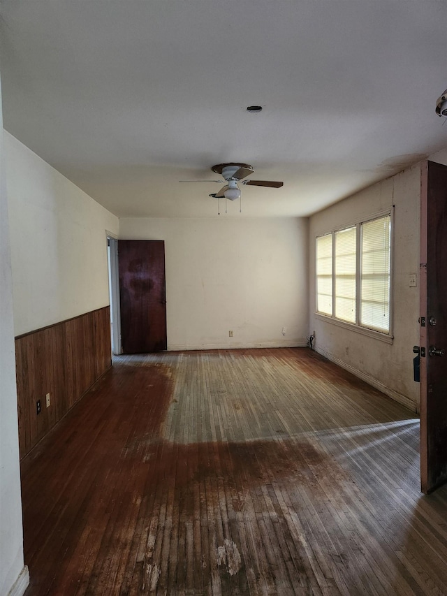 970 Peyton Dr, Beaumont, TX 77706 - spare room with wood-type flooring, ceiling fan, wainscoting, and wood walls