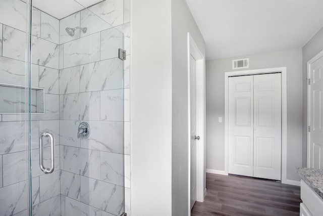 bathroom featuring a shower with door, vanity, and hardwood / wood-style flooring