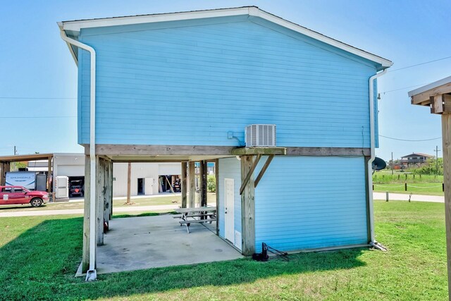 back of house featuring a carport and a yard