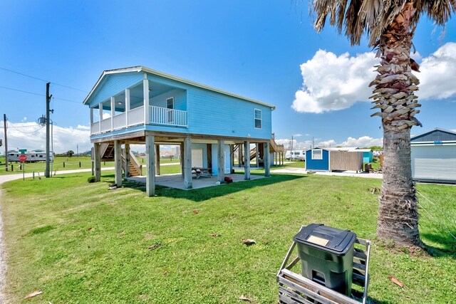 back of property with a patio area, a lawn, and stairs