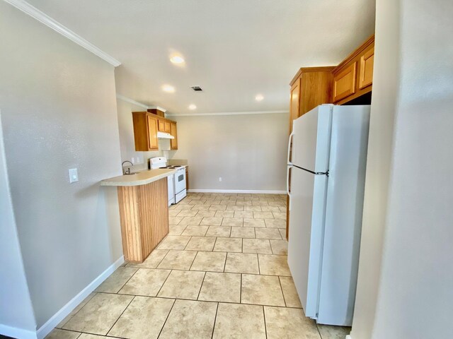 kitchen featuring baseboards, light countertops, white appliances, and crown molding