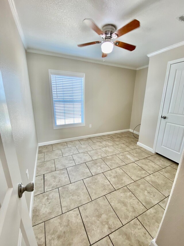 unfurnished room with light tile patterned floors, a textured ceiling, baseboards, and crown molding