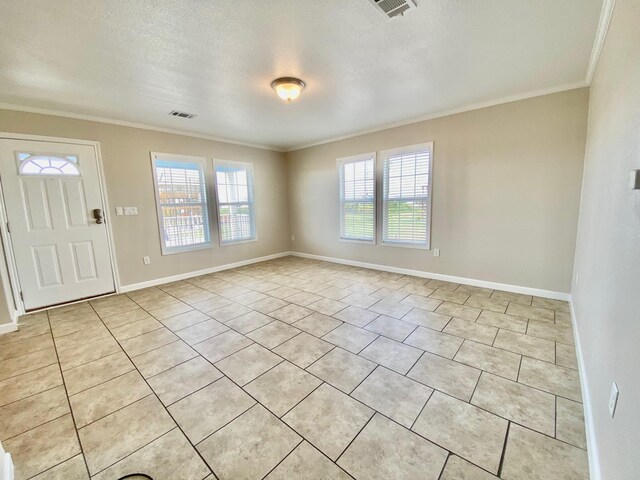 foyer featuring a textured ceiling, ornamental molding, visible vents, and baseboards