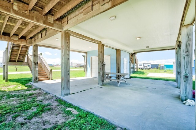 view of patio featuring a garage and stairway