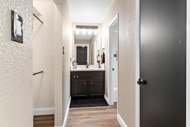 bathroom featuring vanity, wood-type flooring, and a textured ceiling