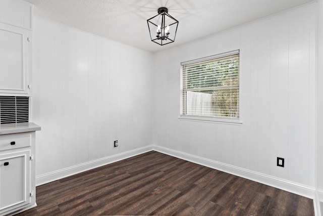 unfurnished dining area with a notable chandelier and dark hardwood / wood-style floors