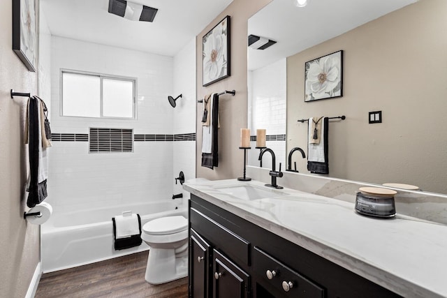 full bathroom featuring vanity, hardwood / wood-style flooring, toilet, and tiled shower / bath