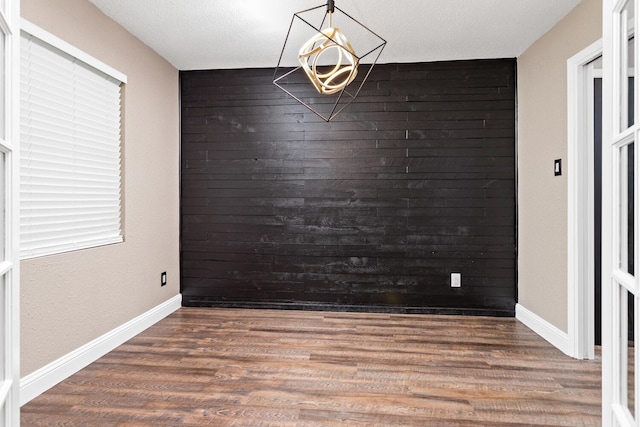 unfurnished room with dark hardwood / wood-style flooring and a textured ceiling