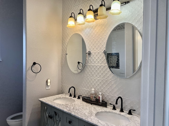 bathroom with backsplash, vanity, and toilet