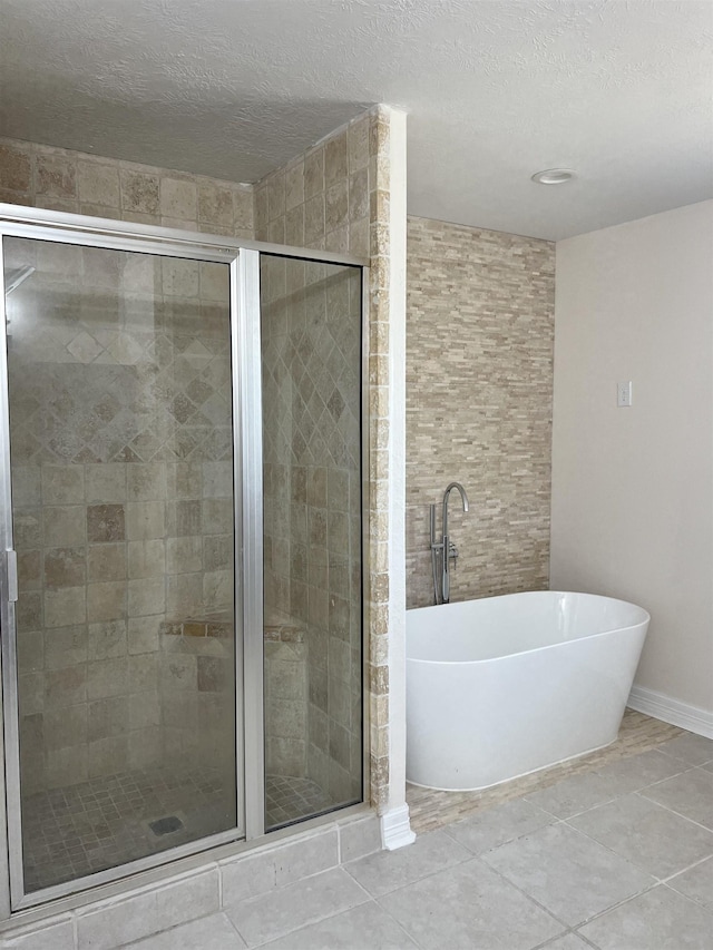 bathroom with tile patterned floors, a textured ceiling, and independent shower and bath