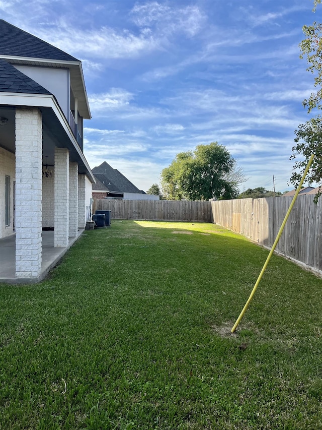 view of yard featuring central AC unit and a patio area