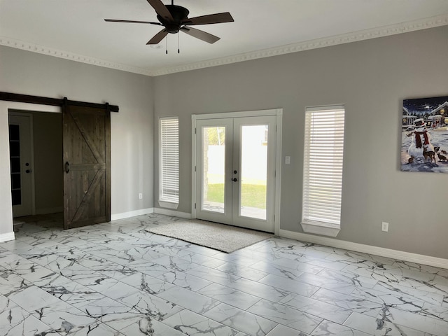 interior space featuring a barn door, ceiling fan, crown molding, and french doors