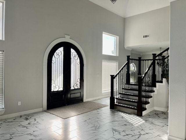 entryway featuring a towering ceiling and french doors