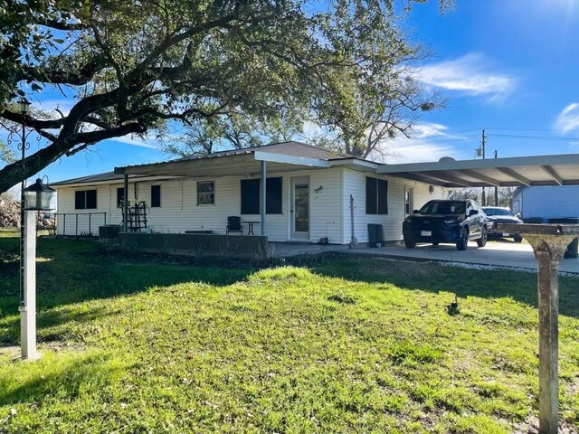 single story home featuring a front yard, a porch, and a carport