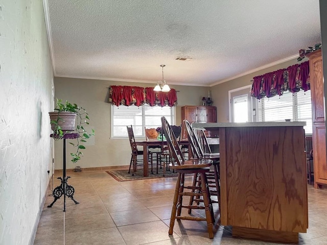 tiled dining room featuring a textured ceiling, an inviting chandelier, and ornamental molding