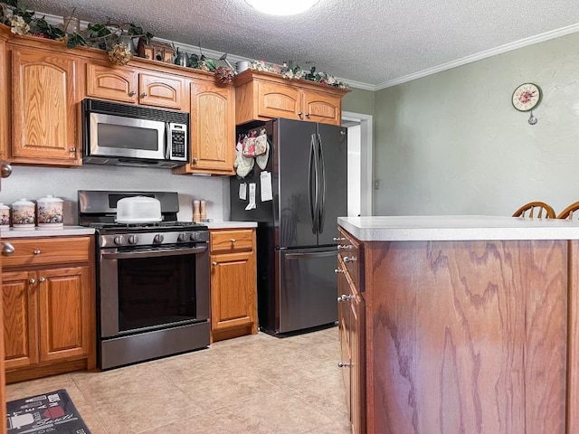 kitchen with light tile patterned floors, a textured ceiling, stainless steel appliances, and crown molding