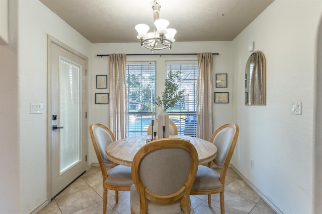 dining room featuring light tile patterned floors, a textured ceiling, and a notable chandelier