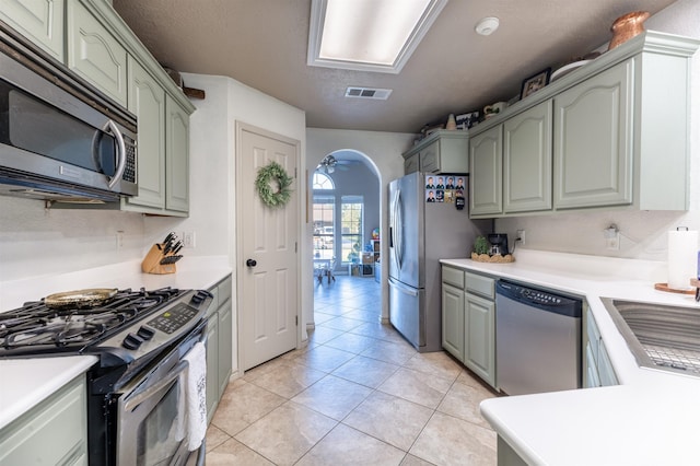 kitchen with ceiling fan, light tile patterned flooring, sink, and stainless steel appliances