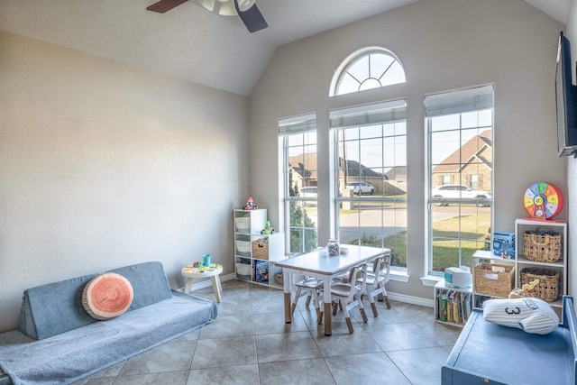 tiled dining space with a wealth of natural light, ceiling fan, and lofted ceiling