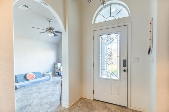 foyer entrance with plenty of natural light, ceiling fan, light tile patterned flooring, and vaulted ceiling