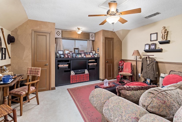 carpeted living room with ceiling fan, vaulted ceiling, and a textured ceiling