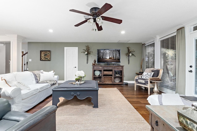 living room featuring ceiling fan, dark hardwood / wood-style flooring, and decorative columns