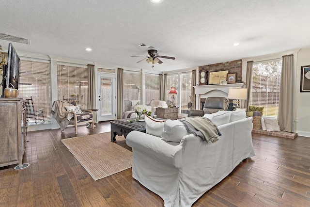 living room featuring dark hardwood / wood-style flooring, plenty of natural light, and a textured ceiling