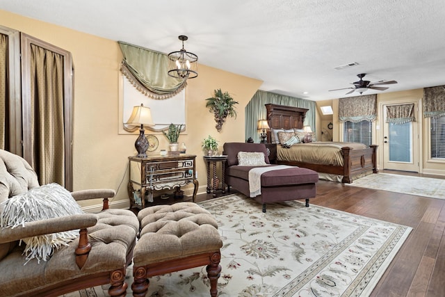 bedroom featuring wood-type flooring, a notable chandelier, and a textured ceiling