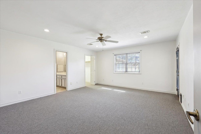 empty room with light colored carpet, baseboards, a ceiling fan, and visible vents