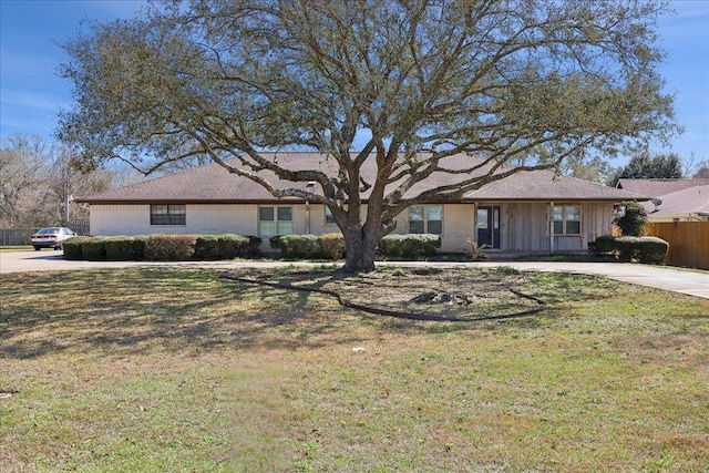 ranch-style house with concrete driveway, a front yard, and fence