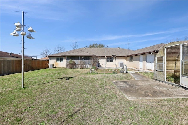 back of property with a fenced backyard, a patio, and a lawn