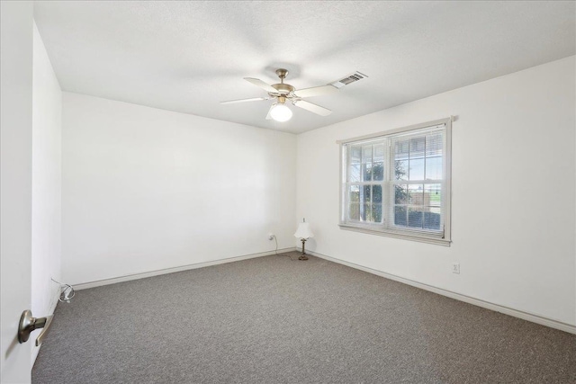 unfurnished room with visible vents, baseboards, a ceiling fan, and carpet