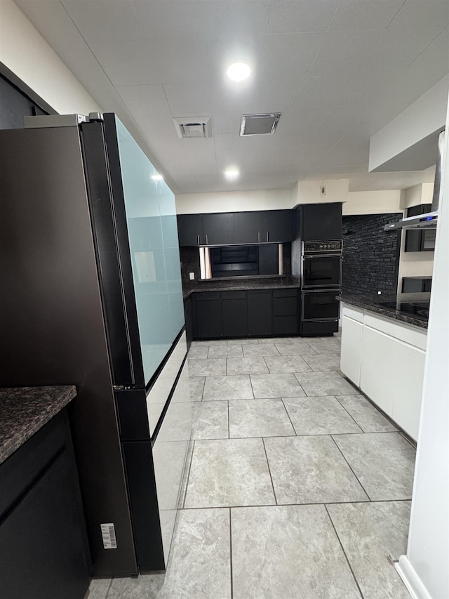 kitchen with white cabinetry, black appliances, tasteful backsplash, and light tile patterned floors