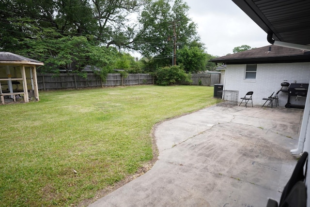 view of yard featuring a fenced backyard, a patio area, and central AC