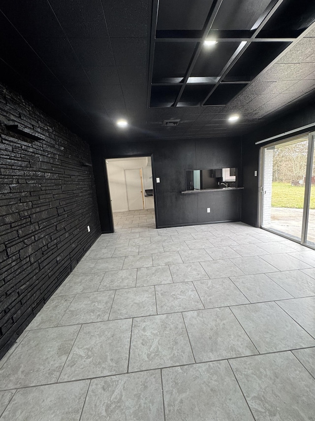 spare room featuring tile patterned floors and brick wall