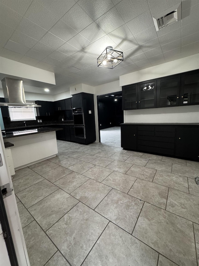 kitchen featuring light tile patterned floors and island exhaust hood