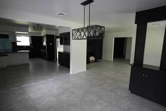 unfurnished dining area with light tile patterned floors, visible vents, and a fireplace